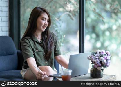 freelance people business female casual working taking note on digital tablet with electronic pen with laptop computer with coffee cup in coffee shop like the background,communication concept