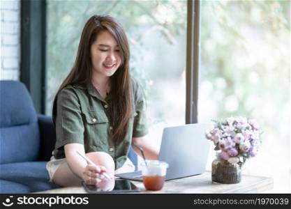 freelance people business female casual working taking note on digital tablet with electronic pen with laptop computer with coffee cup in coffee shop like the background,communication concept