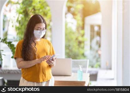 freelance people business female wearing protective mask casual and writing message on smartphone working with laptop computer ,working from home,Concept of Prevention of the spread of COVID-19 virus