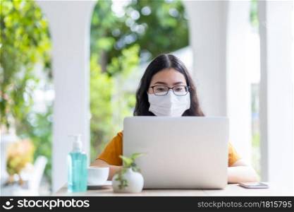 freelance people business female wearing protective mask casual working with laptop computer in coffee shop like the background,working from home,Concept of Prevention of the spread of COVID-19 virus