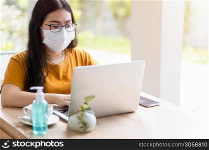 freelance people business female wearing protective mask casual working with laptop computer in coffee shop like the background,working from home,Concept of Prevention of the spread of COVID-19 virus