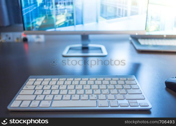 Freelancer's workplace: Keyboard in the foreground, blurry screen in the background