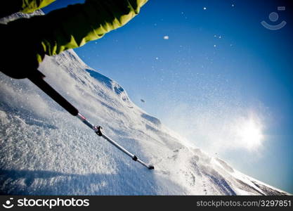 Freerider skier moving down in snow powder at sunset (detail)