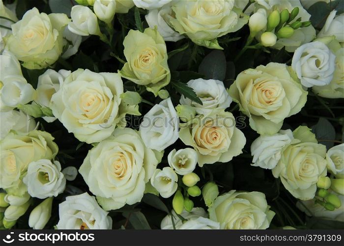 Freesias and roses in a white bridal arrangement