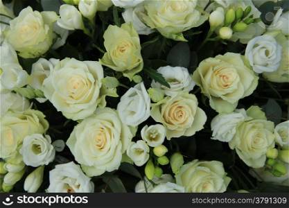 Freesias and roses in a white bridal arrangement
