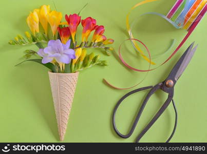 Freesias flowers in ice cream waffles and vintage scissors