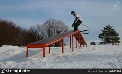 freestyle skier grinding down a rail