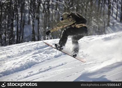 freestyle snowboarder jump and ride free style at sunny winter day on mountain