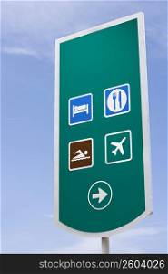 Freeway sign for airport, hotel, restaurant and beach, Spanish
