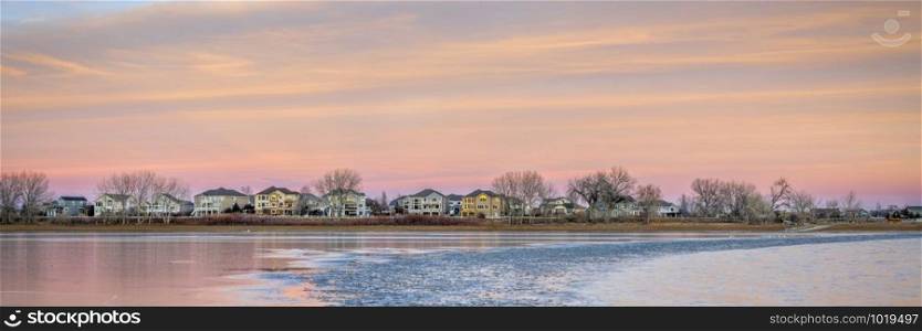 freezing lake after sunset with houses at waterfront - Boyd Lake in northern Colorado, panoramic banner