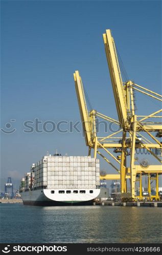 Freighter in port being loaded with containers.Cranes in port