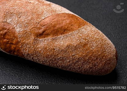 French baguette bread on a dark textured concrete background. Making delicious bruschetta at home