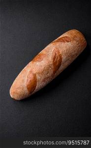 French baguette bread on a dark textured concrete background. Making delicious bruschetta at home