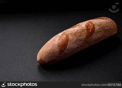 French baguette bread on a dark textured concrete background. Making delicious bruschetta at home