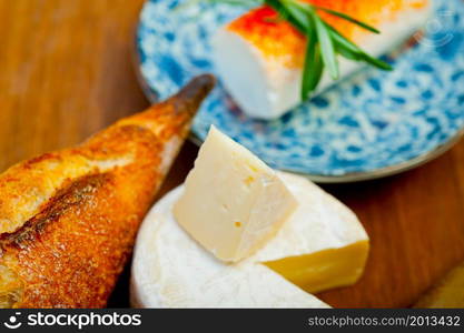 French cheese and fresh baguette on a wood cutter