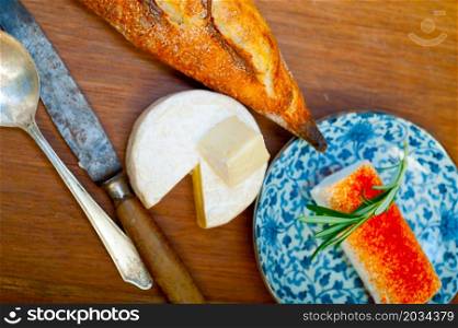 French cheese and fresh baguette on a wood cutter