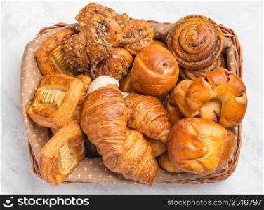 French croissants and pastry products in the basket. Top view. croissants and pastries