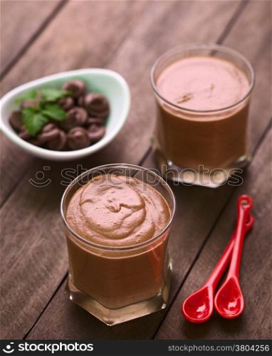French dessert called Mousse au Chocolat, made of melted chocolate, egg, cream and sugar served in glasses with two small spoons on the side (Selective Focus, Focus onto the middle of the first dessert)