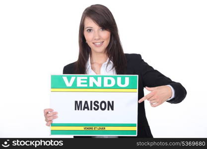 French Estate Agent with a &rsquo;Vendu&rsquo; sign