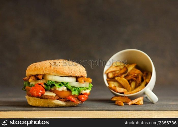 French fries and juicy meat burger with beef, cheese, tomatoes ,lettuce, onion. 