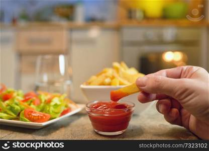 French fries and salad on table in kitchen