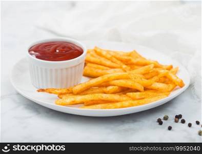 French fries chips with tomato ketchup in white plate on white marble table background with white cloth.