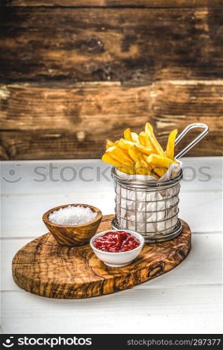 French fries in a basket with salt and ketchup