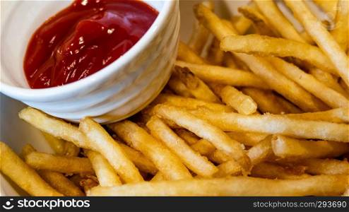 French fries in white bowl with ketchup on side