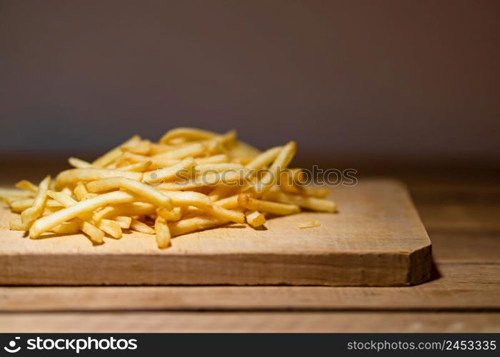 French fries on a wooden table. Food, junk food and fast food concept