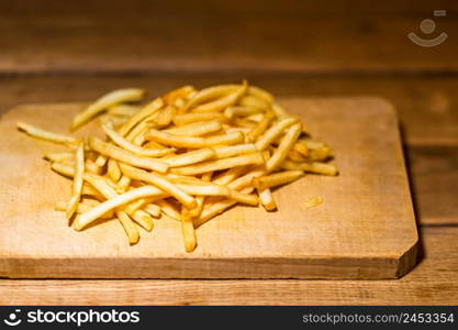 French fries on a wooden table. Food, junk food and fast food concept