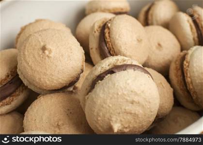 French homemade macarons pile closeup in porcelain bowl