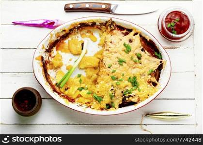 French meat is a dish made from layers of meat, potatoes and cheese. Meat and potato casserole. Baked meat with potatoes and cheese.