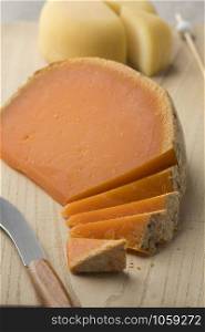 French Mimolette cheese cut into pieces on a cutting board