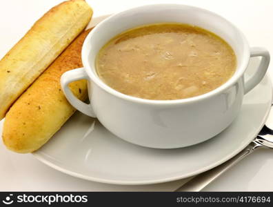 French Onion Soup in a white bowl with bread sticks