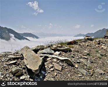 French Pyrenees mountains range in fog with big stone on the foreground HDR processed