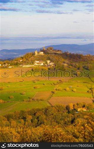 French rural landscape with a castle on a hill in a distance.