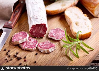 French salami with rosemary on wooden board