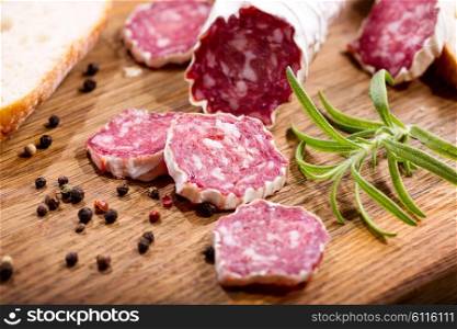 French salami with rosemary on wooden board