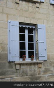 French style window with painted wooden shutters