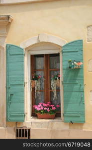 French style window with painted wooden shutters