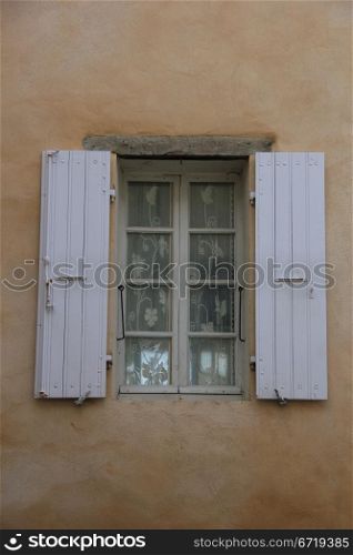 French style window with painted wooden shutters
