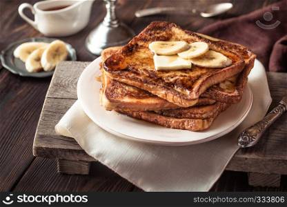 French toast with butter, sliced banana and maple syrup