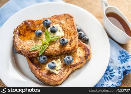 French toasts with fresh blueberries and maple syrup