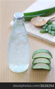 Fresh aloe vera and jelly in Glass bottle placed on a wooden flo. Fresh aloe vera and jelly in Glass bottle placed on a wooden floor and have copy space to input for design in your work.