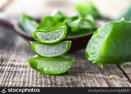 Fresh aloe vera leaves and slices of aloe vera on a wooden background. Aloe for treatment and skin care.. Fresh aloe vera leaves and slices of aloe vera on a wooden background.