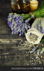 Fresh and dried lavender flowers, essential oil, soap and Herbal massage balls over wooden surface