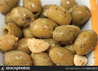 Fresh and healthy appetizers: green olives with herbs and garlic