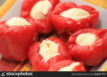 Fresh and healthy appetizers on a square plate: stuffed sweet peppers