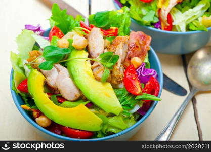 fresh and healthy Chicken Avocado salad over rustic wood table