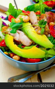 fresh and healthy Chicken Avocado salad over rustic wood table